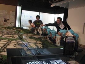 亀山城下町模型で「亀山幼稚園はこのへんだよ」と館長が指示しています